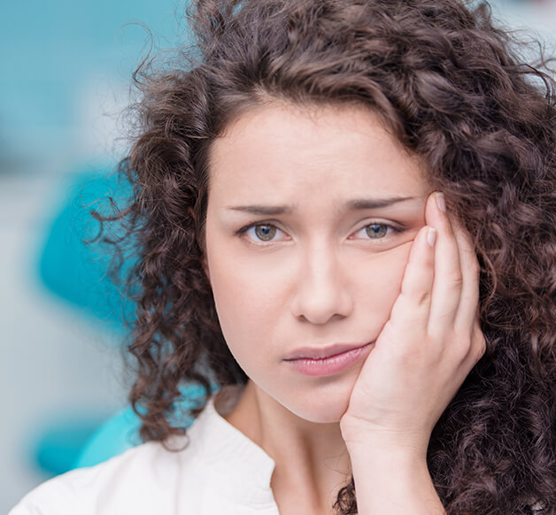 woman holding her mouth in pain