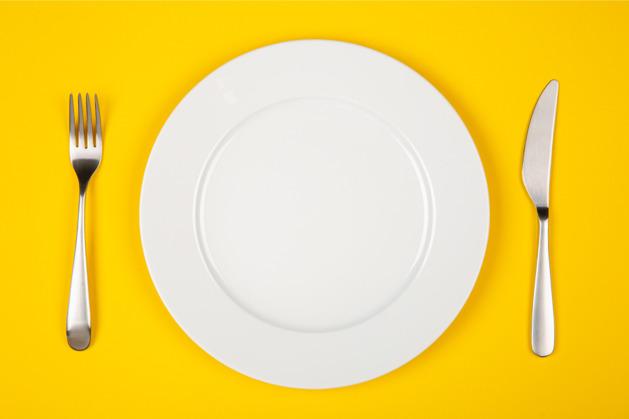 Aerial view of a white plate on a yellow background