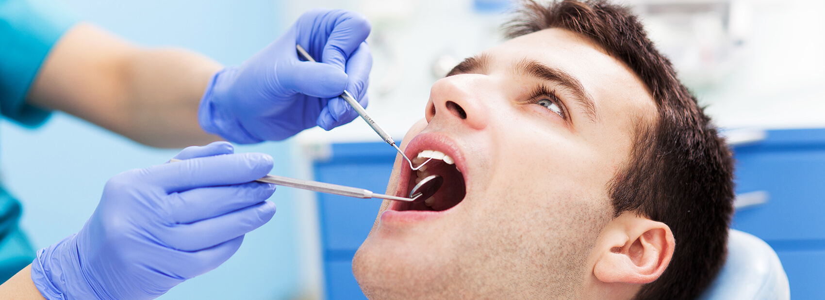 man having his teeth examined by his dentist