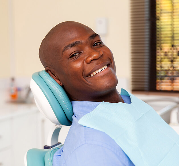 smiling man sitting in a dental chair