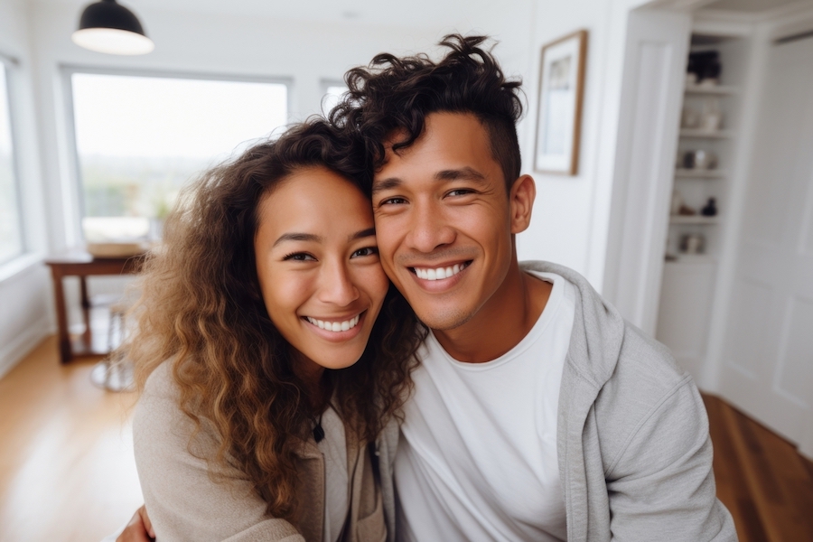 Brown couple smiling with beautiful teeth after cosmetic dentistry